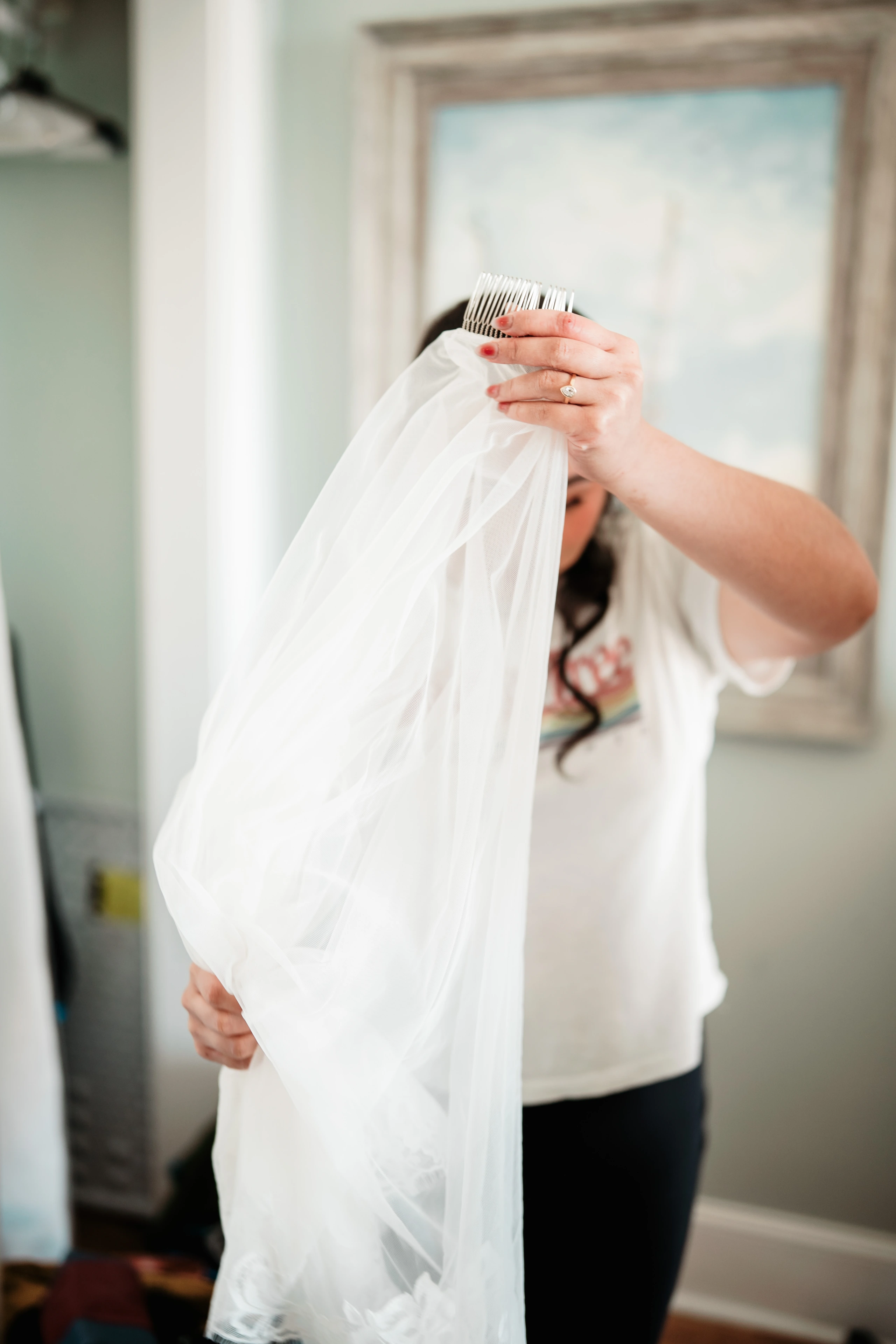 Winter photographer wearing puffy jacket and beanie takes photo with professional camera in woods.