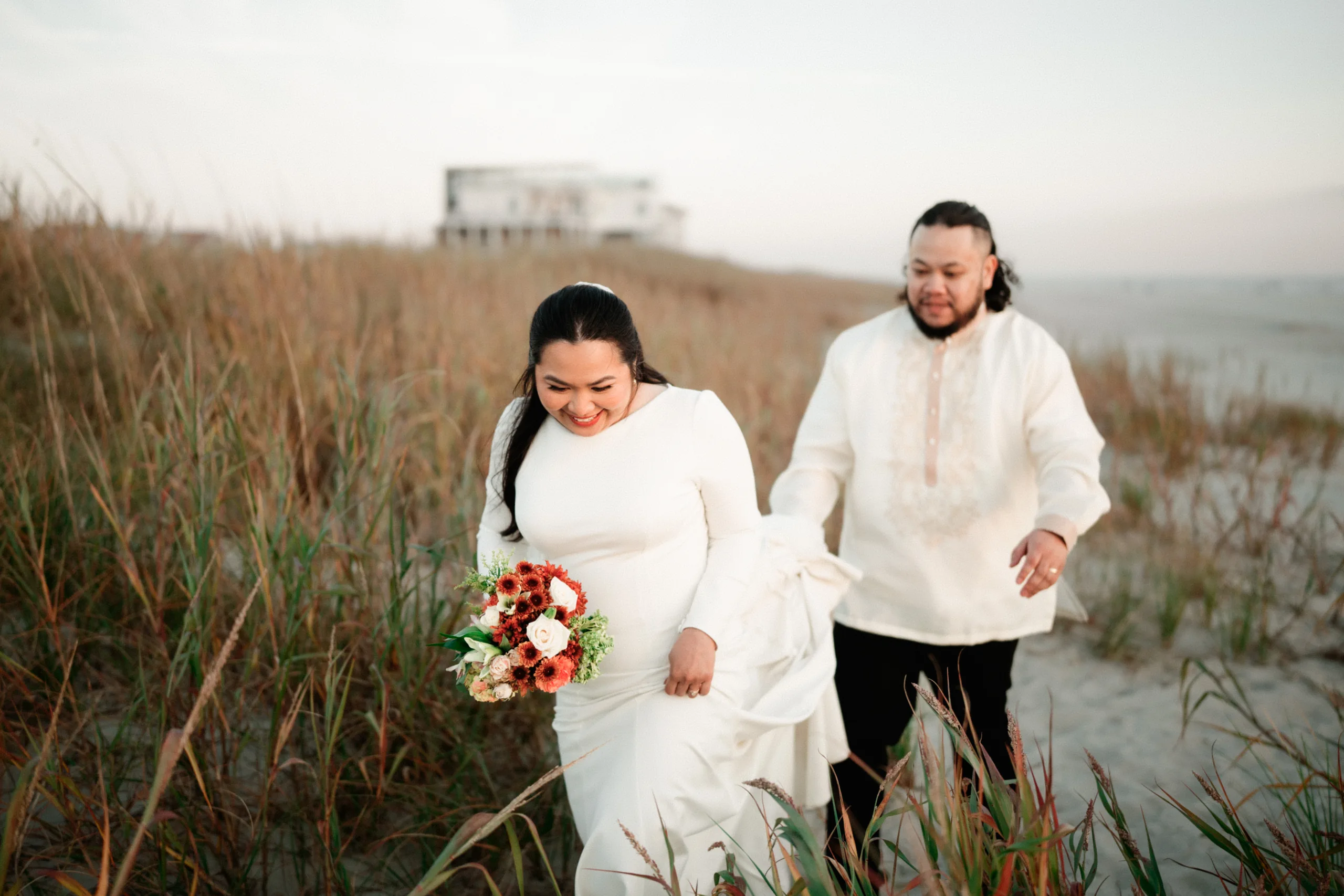A candid moment of joy and laughter during a casual beach wedding celebration.