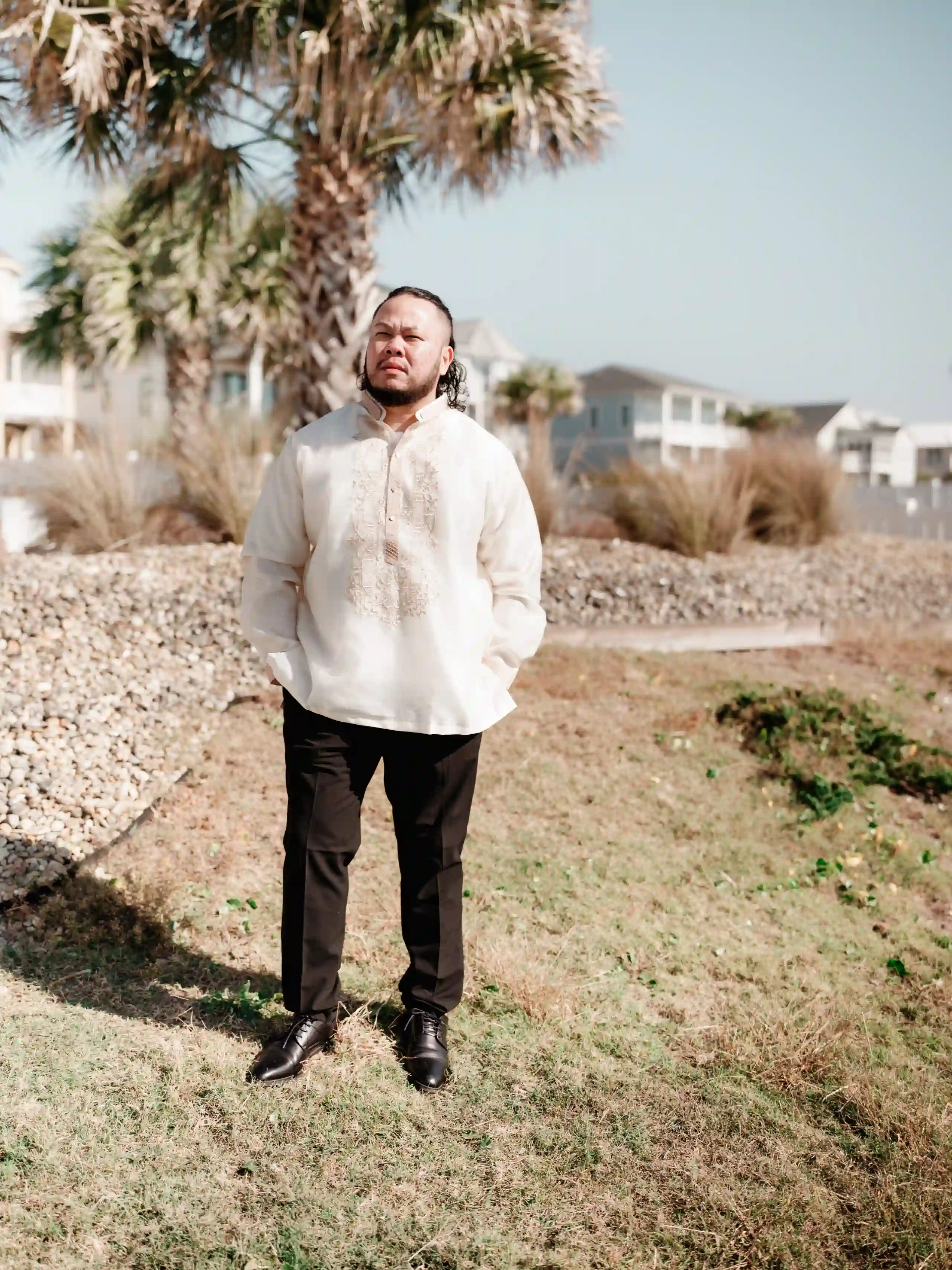 A person in white dress splashing through ocean waves at sunset on a beach.