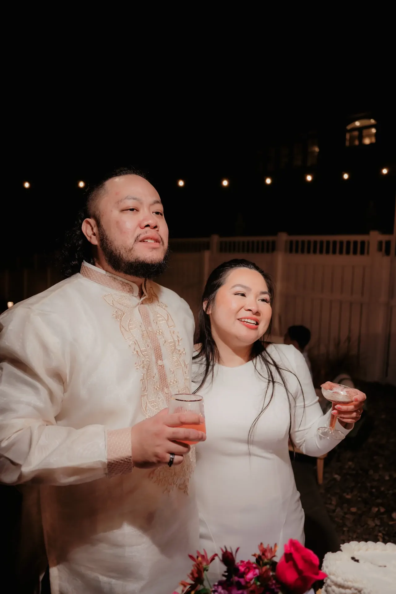 Candid family photo on a beach with a goldendoodle dog standing on a wooden box against a cloudy sky.