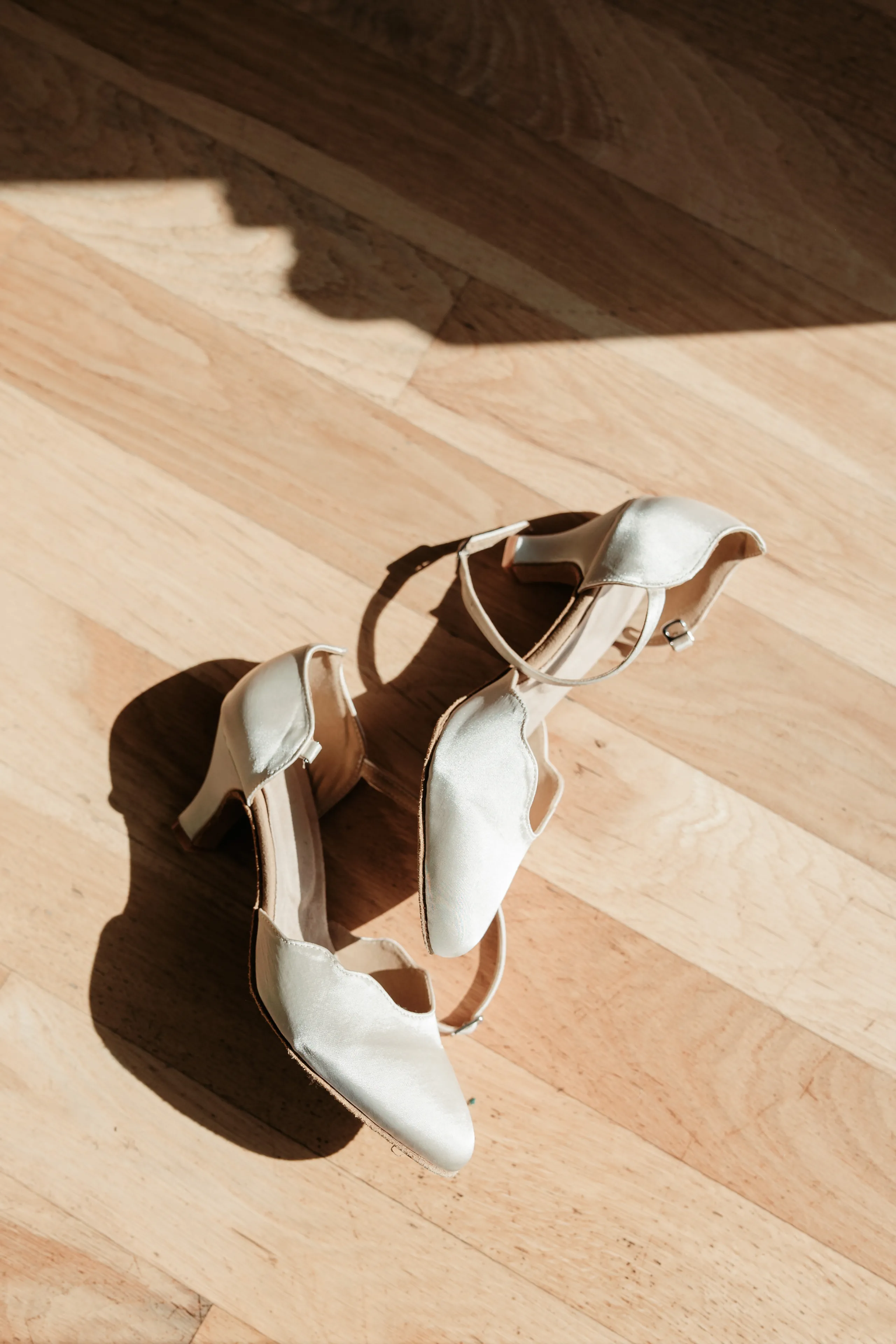 A happy Yorkshire Terrier is lifted up near a decorated Christmas tree with gold and pink ornaments.