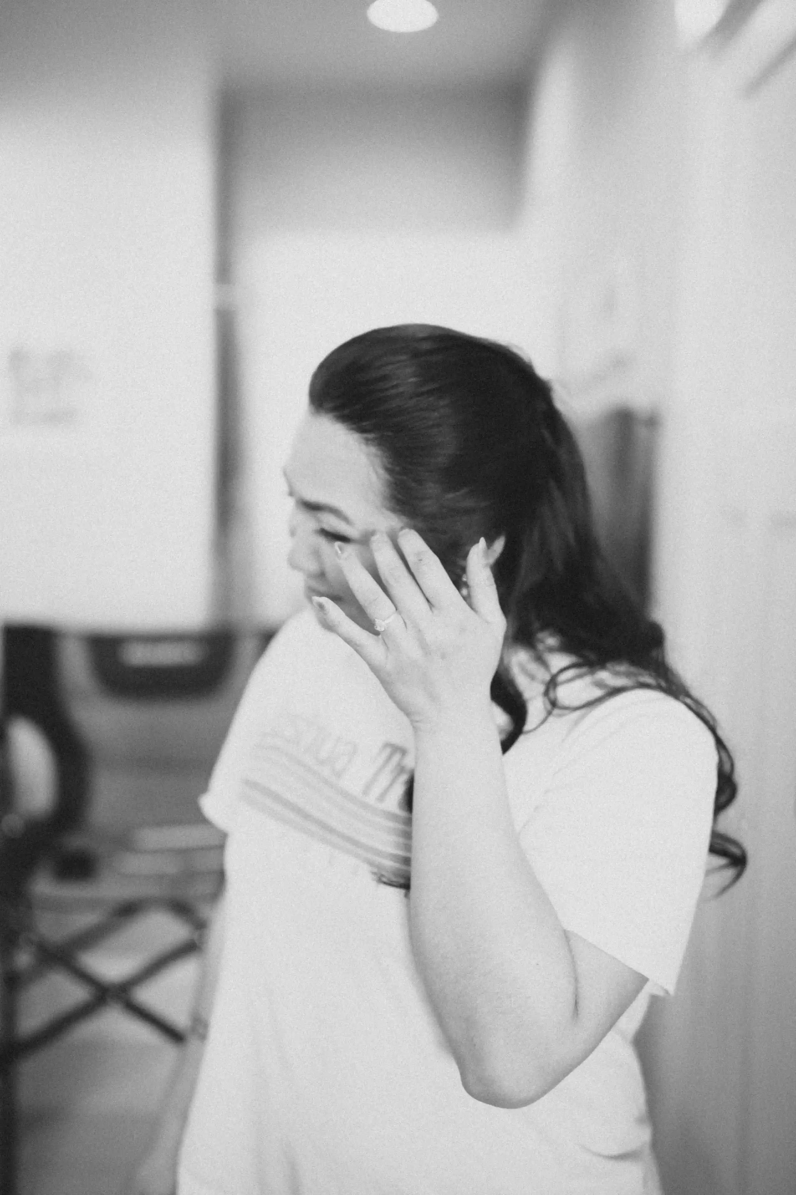 Close-up of hands showing engagement ring against floral dress and casual attire.