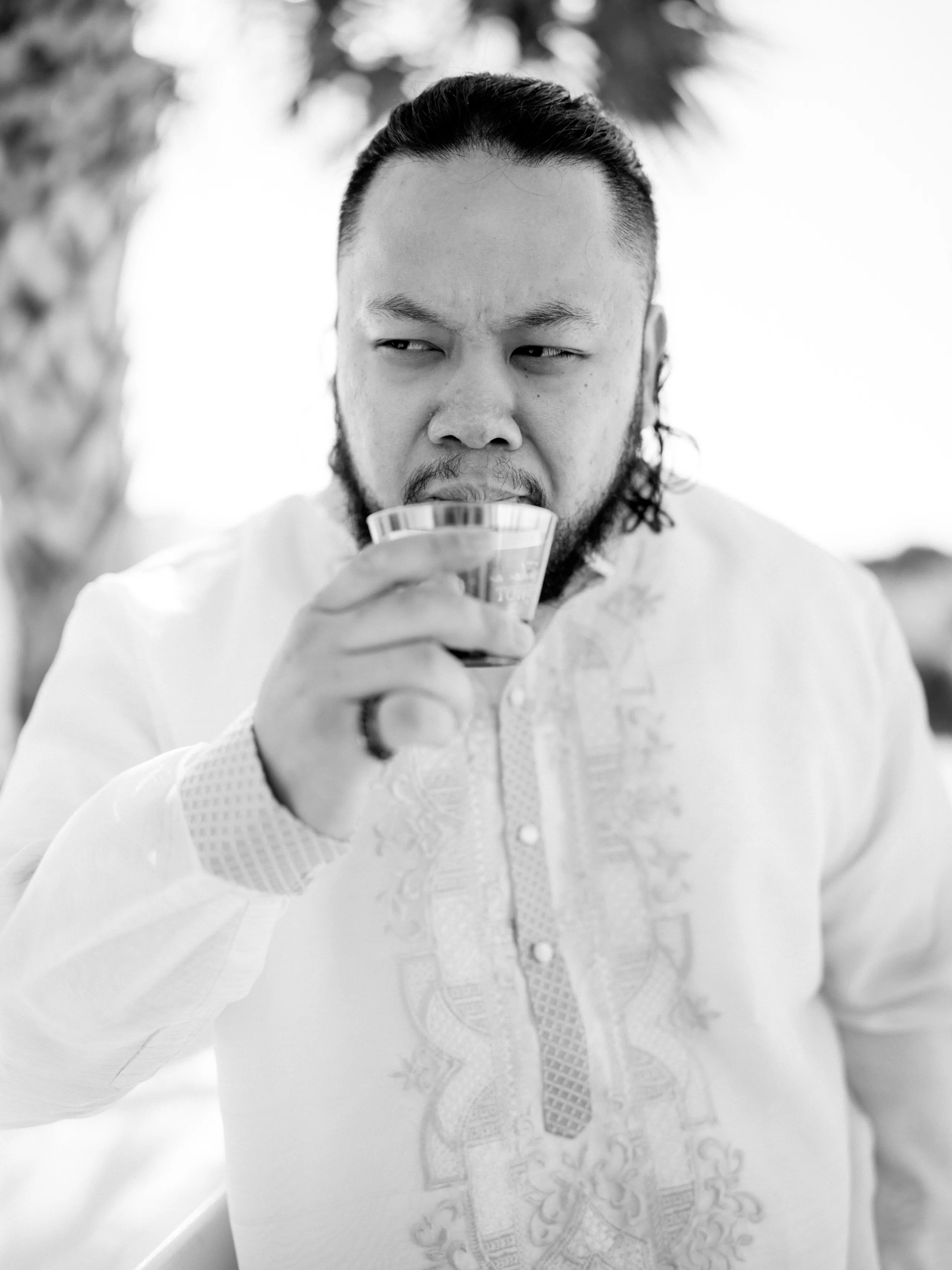 Stone pathway lined with white chairs and greenery at an outdoor garden wedding ceremony.