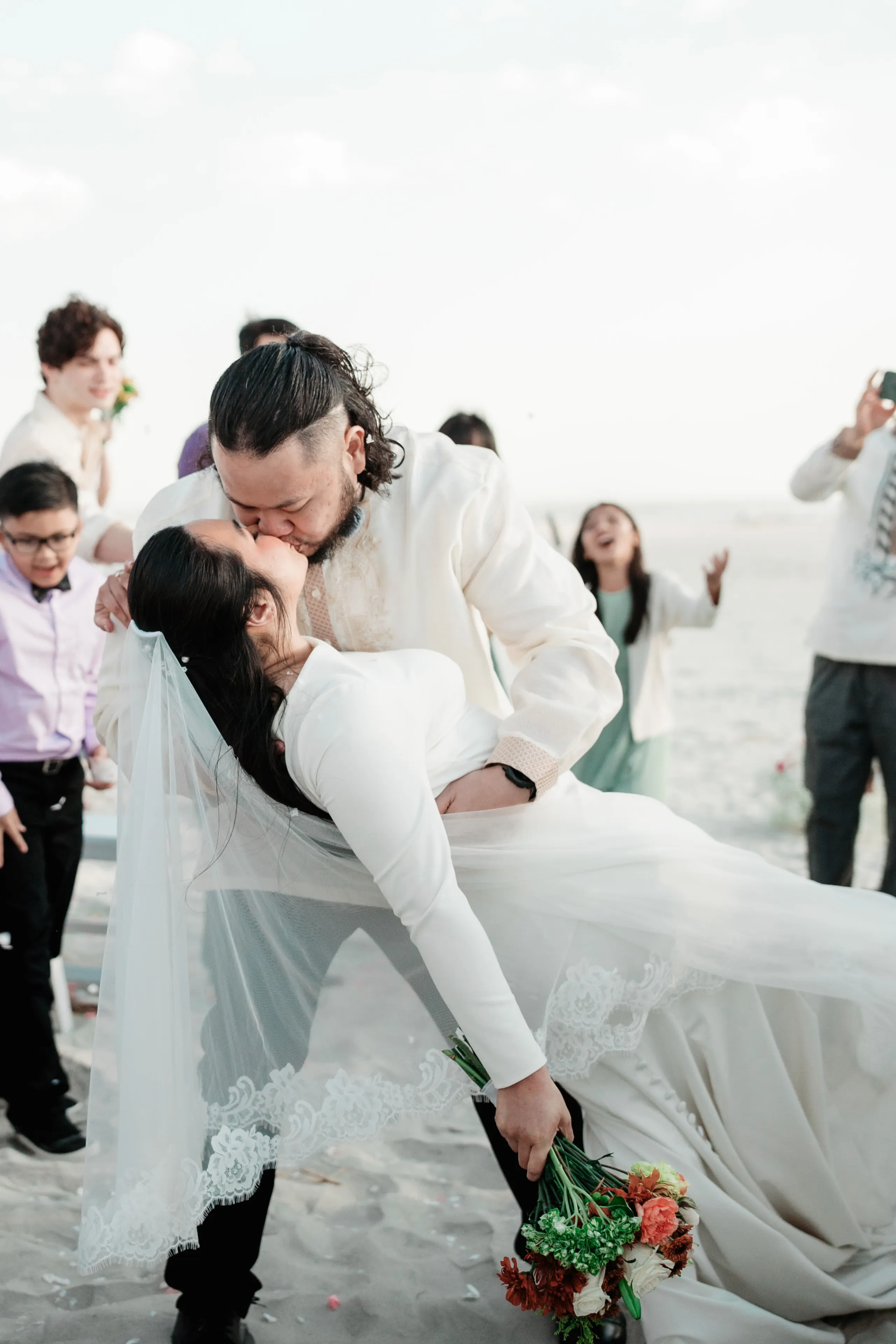 Newlyweds walking down stone path together during outdoor garden ceremony.