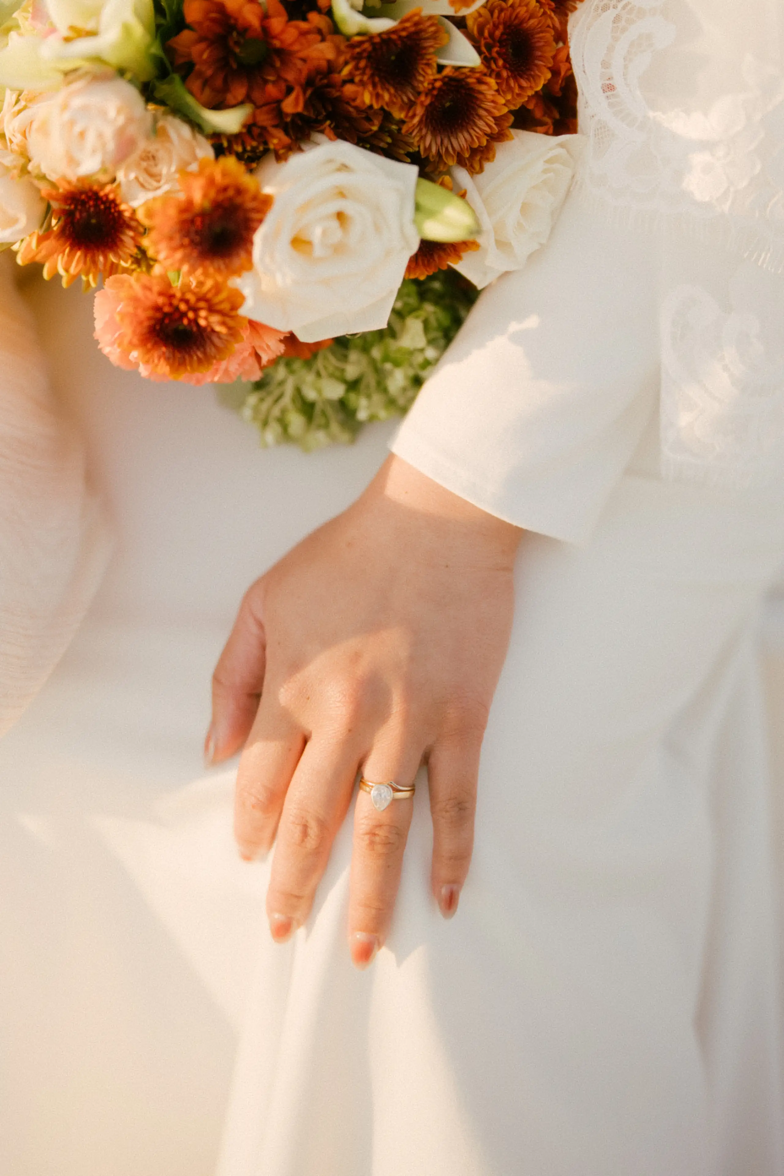 Black and white photo of someone sitting alone on stadium bleachers wearing jeans and a hoodie.